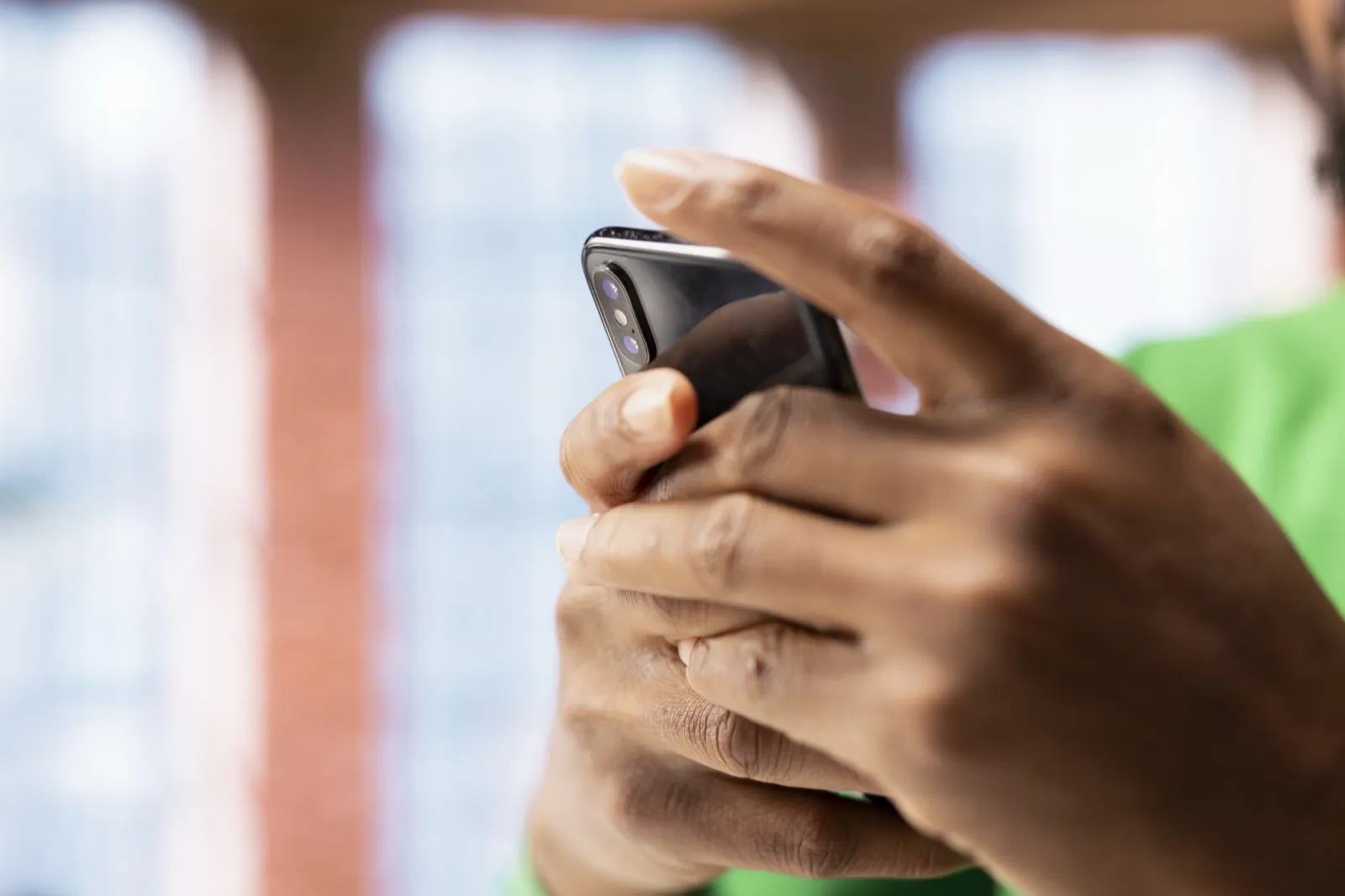 Hands typing on a phone, held up close.